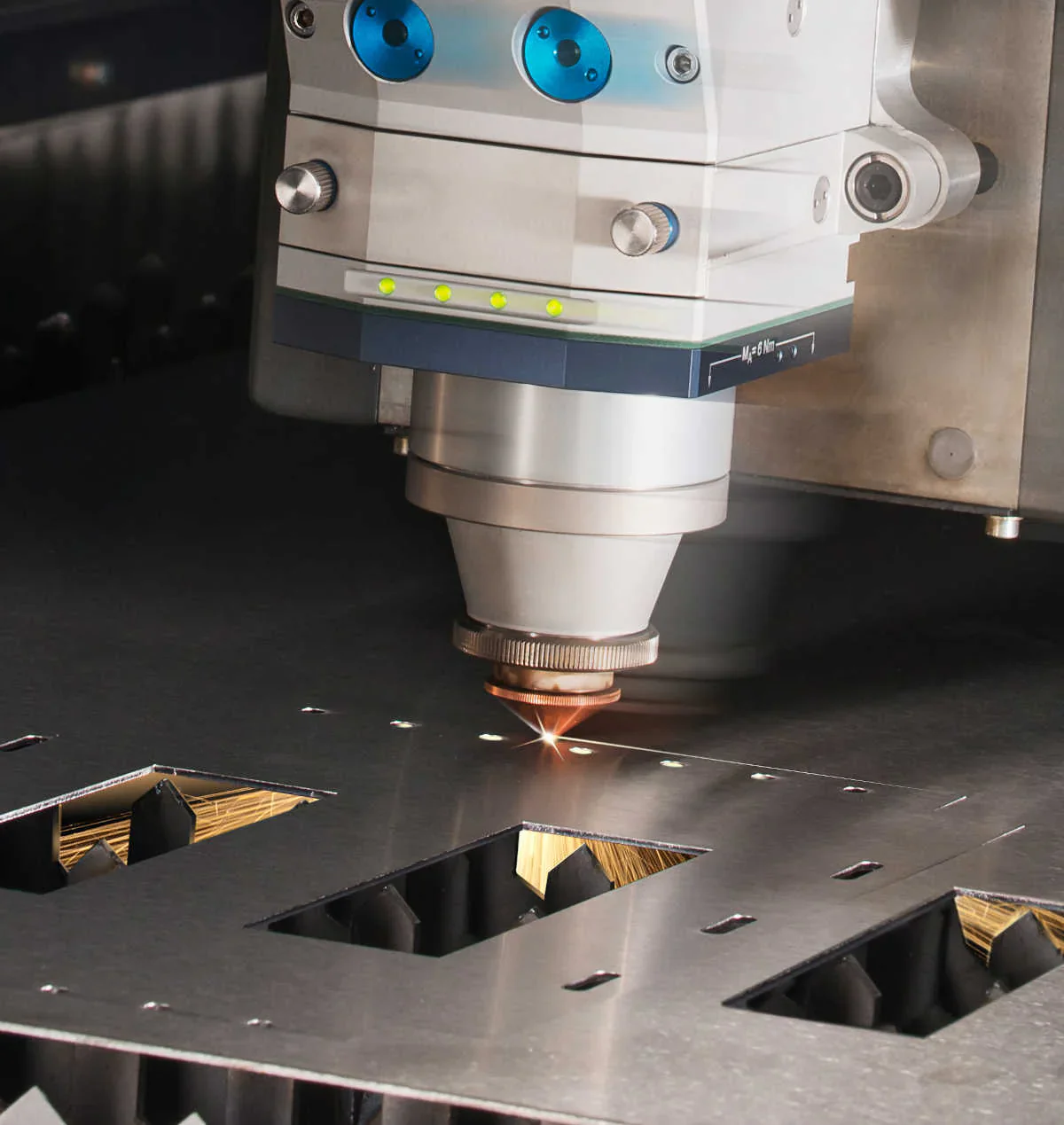 Laser cutting machine performing precision sheet metal fabrication on a metal surface.