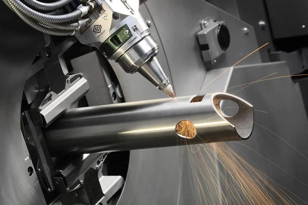 Custom metal fabrication using a high-precision laser cutting system to create detailed openings in a metal tube.