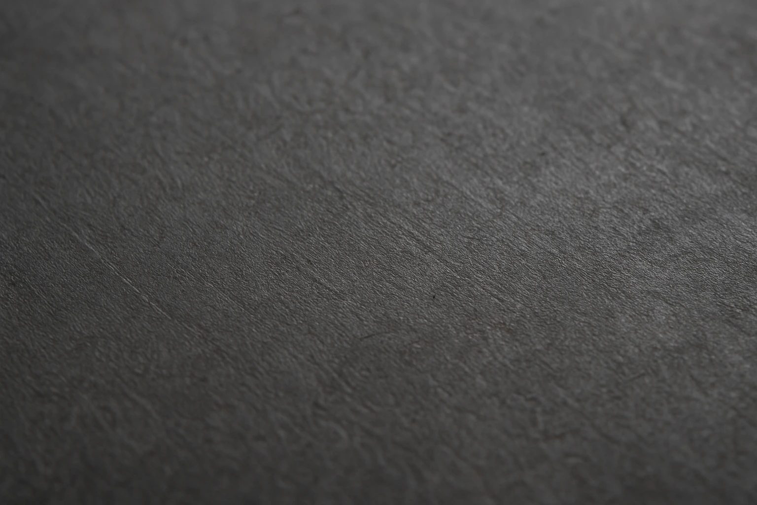 Close-up macro shot of raw carbon steel surface with visible dark texture and grain patterns, created for a detailed carbon vs stainless steel material comparison in an industrial workshop setting.